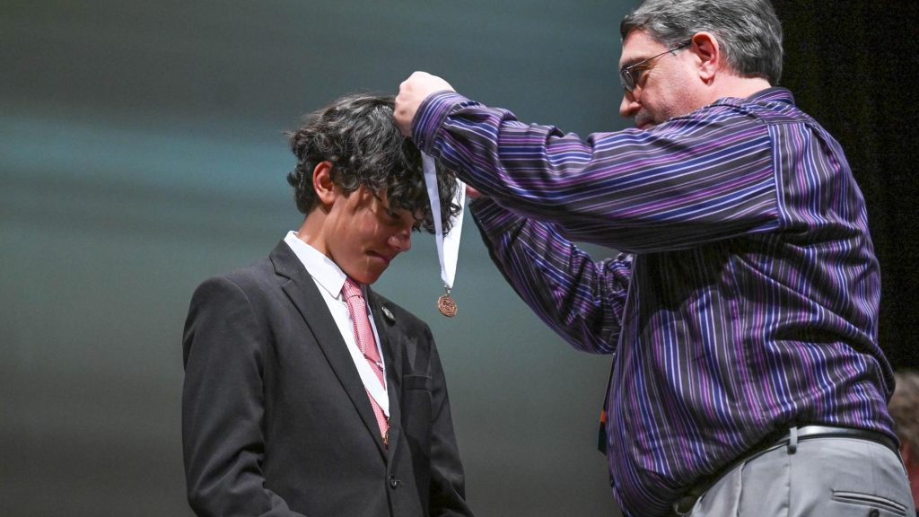 Speech & Debate student being awarded a medal