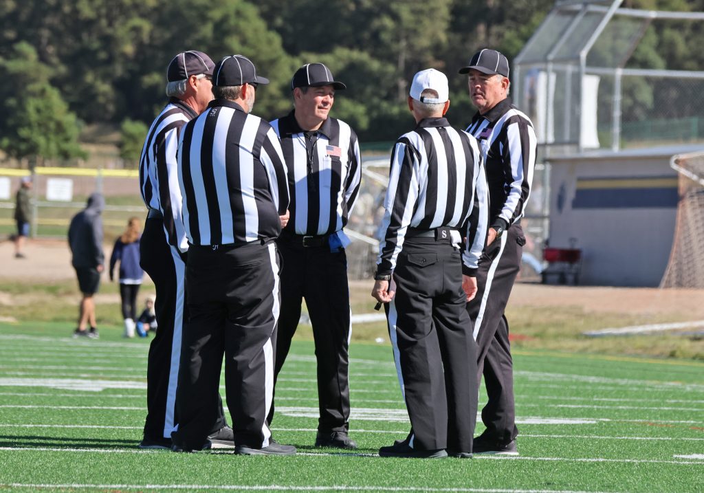 Mark VanGampleare with a group of football officials