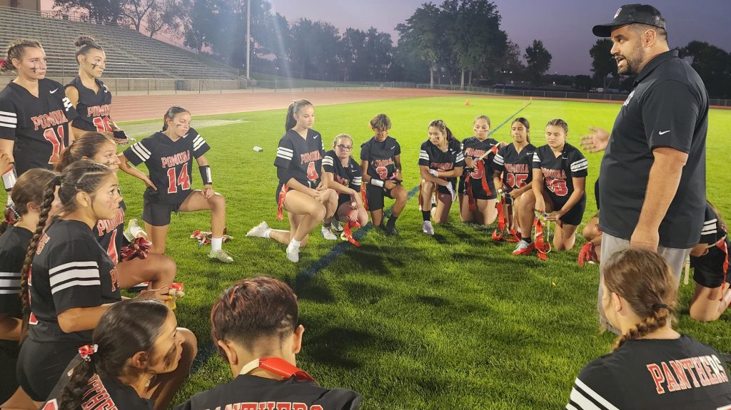 Pomona's Guy Ryan talks to his flag football team