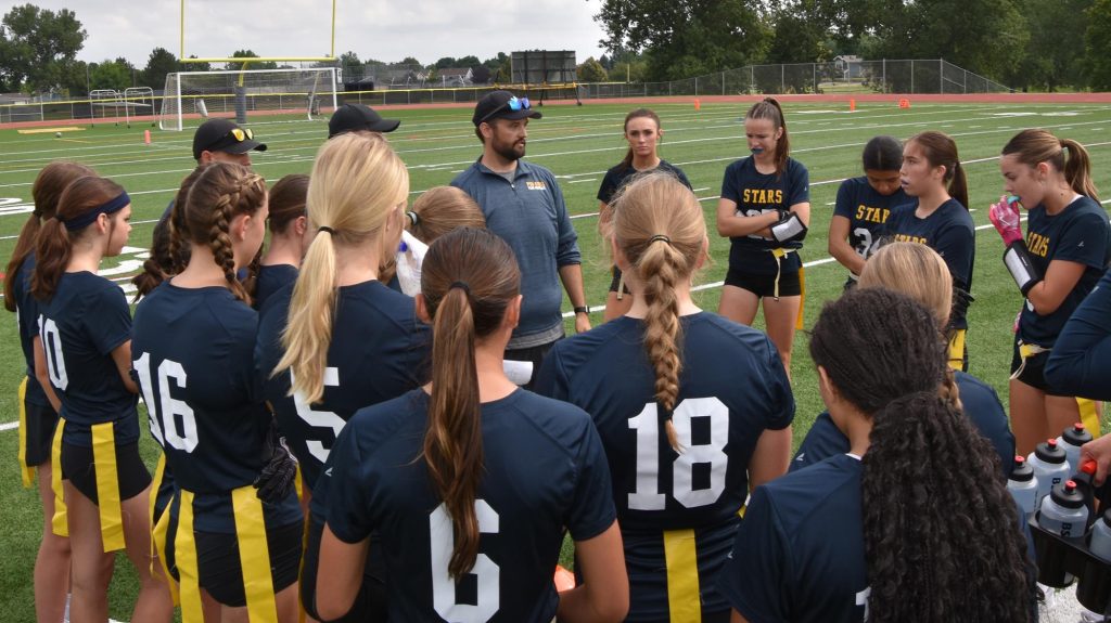 Poudre School District coach Aaron Waters talks to his flag football team