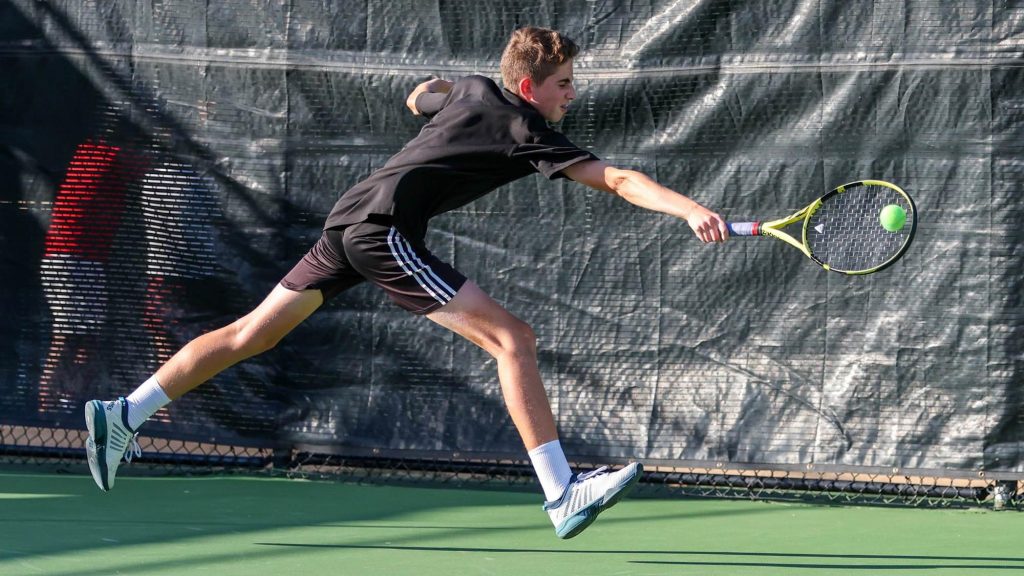 A Fossil Ridge tennis player reaches for a backhand