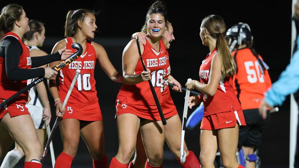 Regis Jesuit field hockey players celebrate